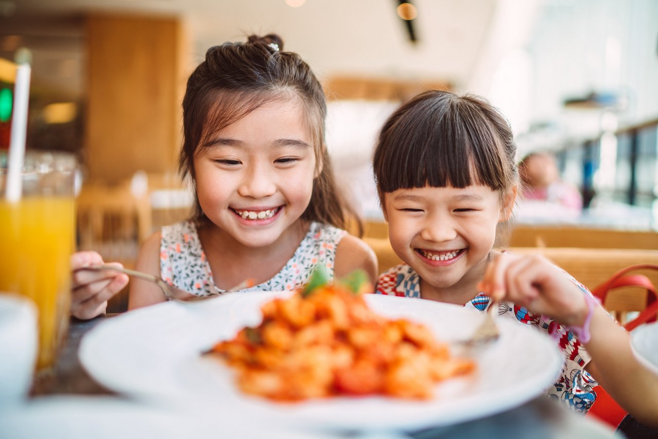 Two kids are having a brilliant meal in a Langham-branded restaurant.