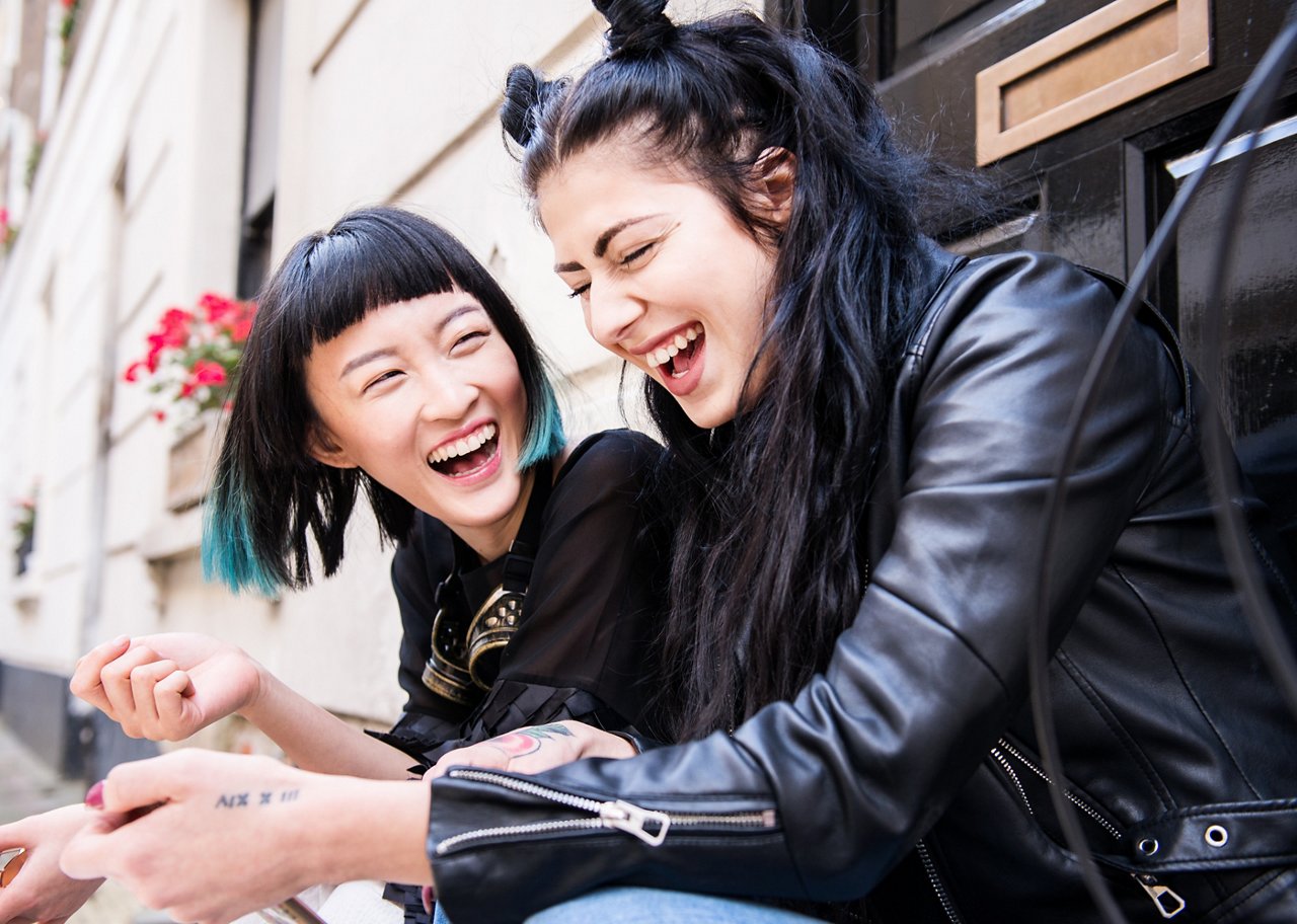 两名女子正在探索朗廷卓逸会应用程式提供的最新优惠。