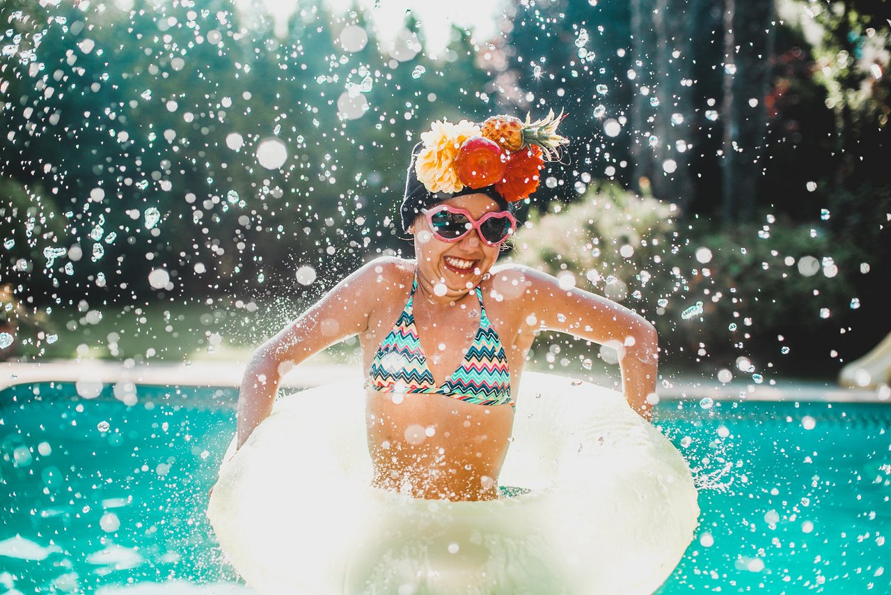 A lady is playing with water in the Langham Hotel swimming pool.